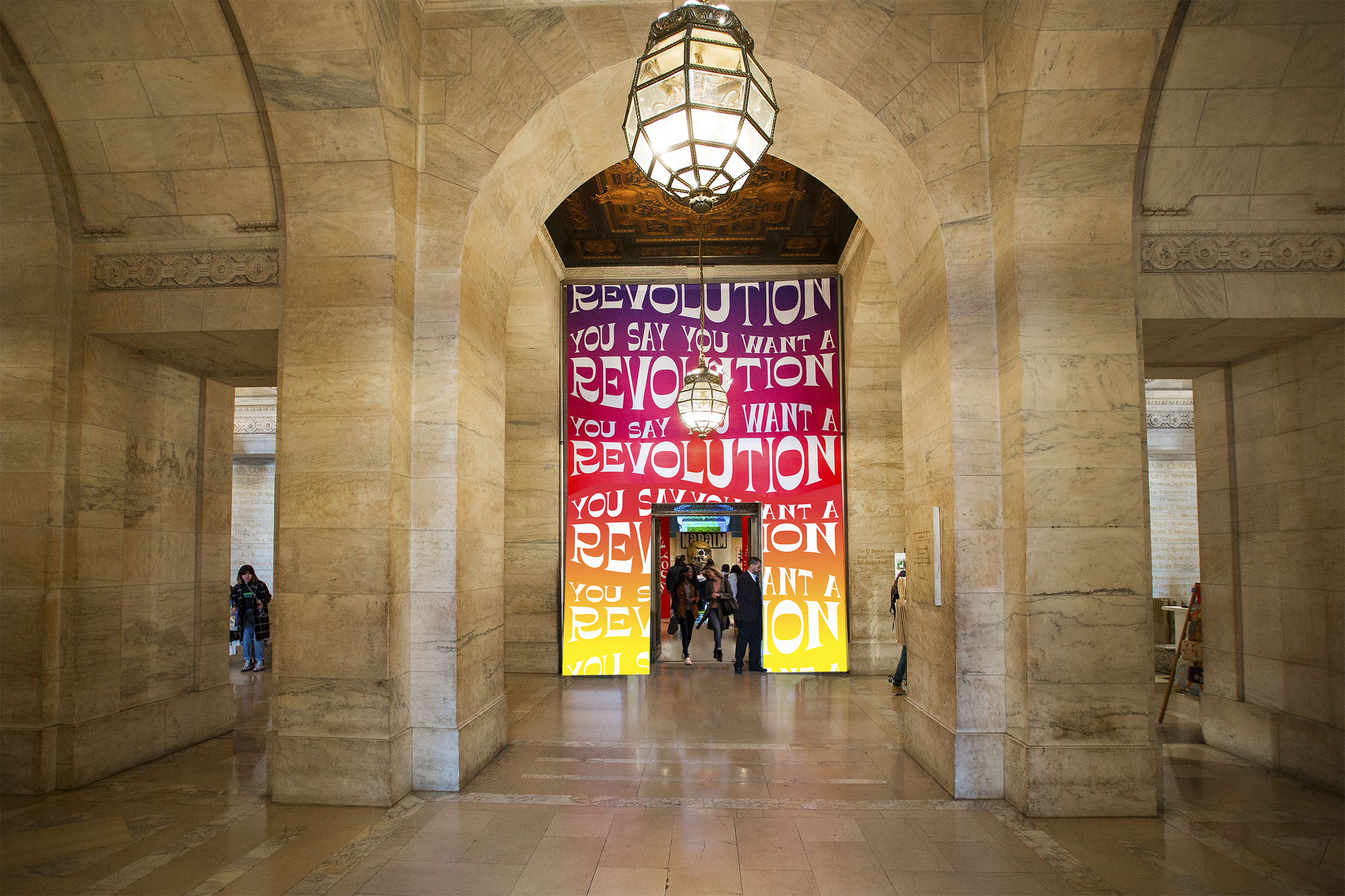 You Say You Want a Revolution door banner in Astor Hall. The gallery entrance often goes unnoticed by visitors; P+A used the bold typography and palette of the exhibition to make the entrance stand out.