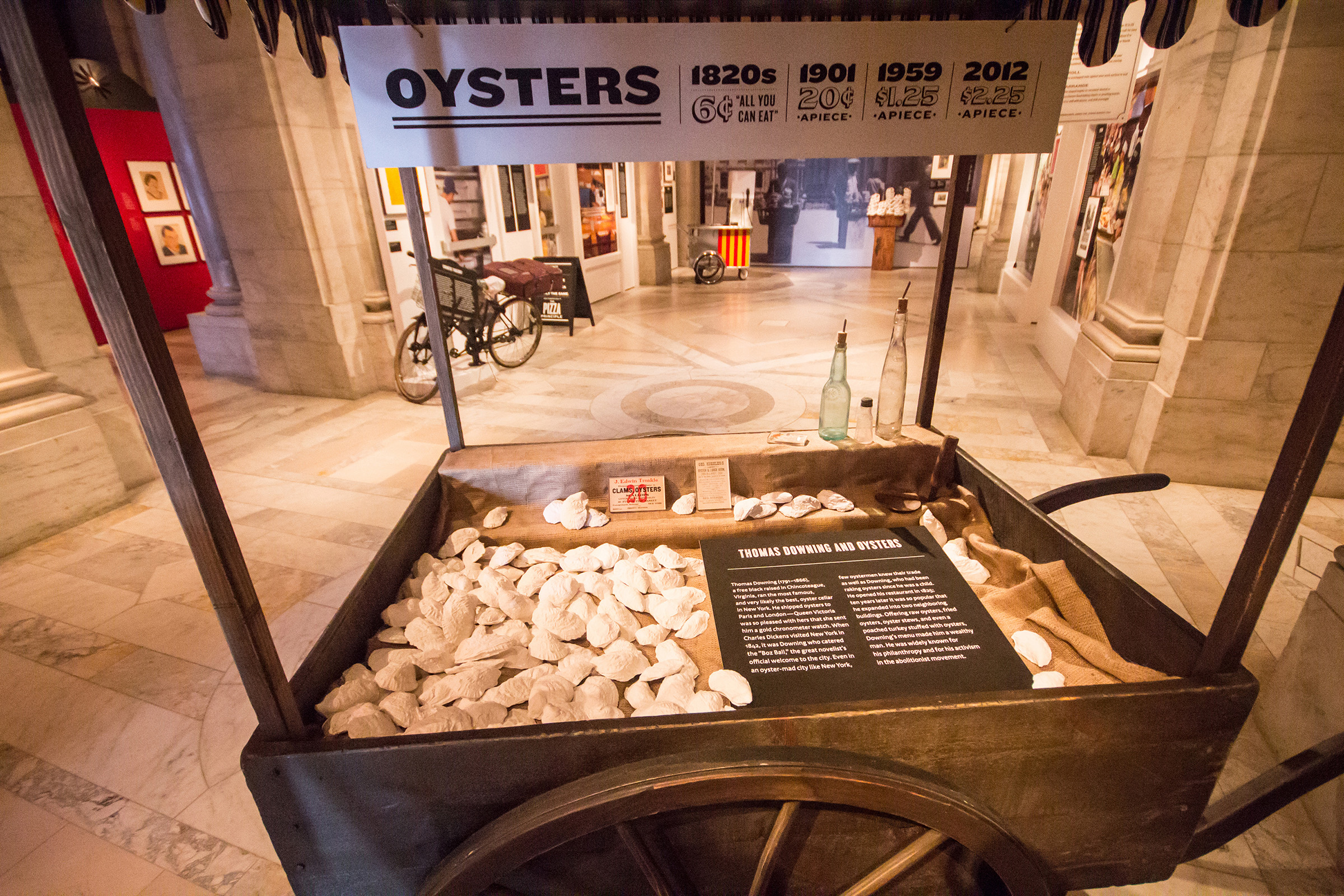 Lunch Hour Exhibition - A detail of the oyster cart showing casts of oyster shells, a brief text history, and a timeline of typical oyster prices.