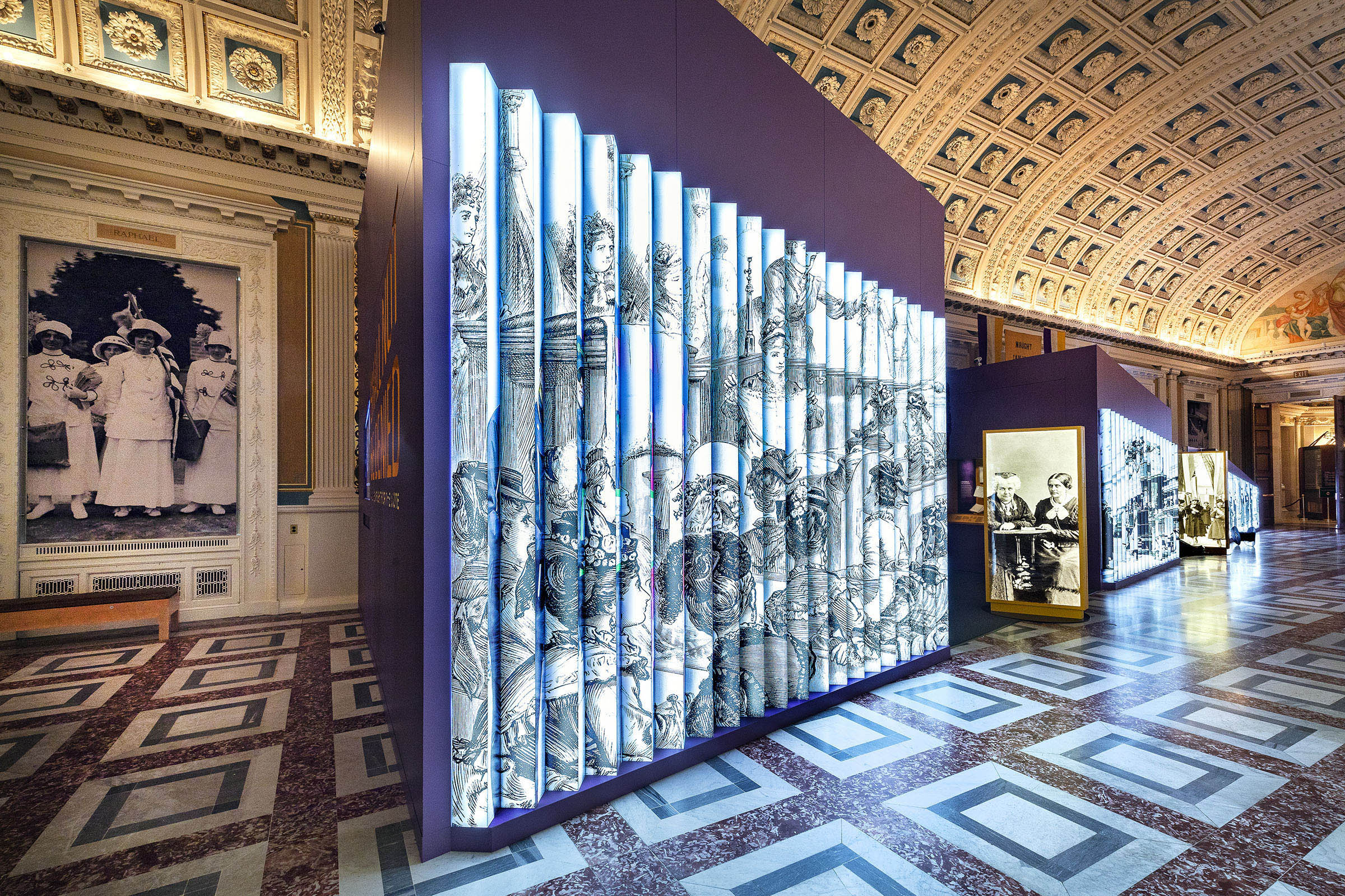 Shall Not Be Denied Exhibition. The “street” is comprised of large, backlit, lenticular images of suffragists protesting—first in private spaces, and then in public—across the 160+ years of the struggle for the vote and the fight for women’s rights.